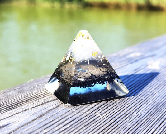 Nahaufnahme einer handgefertigten Orgon-Pyramide mit Schungit, Selenit und goldenen Akzenten.