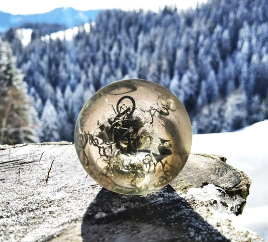 Handgefertigter Orgonit Kegel mit Amethyst, eingebettet in eine natürliche Umgebung, fördert Harmonie und Schutz.