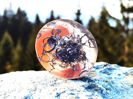 Detailaufnahme des Orgonit-Kegels mit rotem Jaspis und Metallspiralen, symbolisiert kraftvolle Energiearbeit und Schutz.