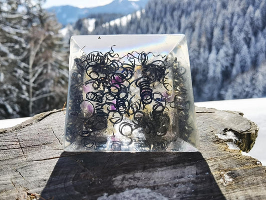 Basisansicht der handgefertigten Lotusblume Orgon-Pyramide mit Metallspänen und Kristallen, präsentiert in einer winterlichen Naturkulisse.